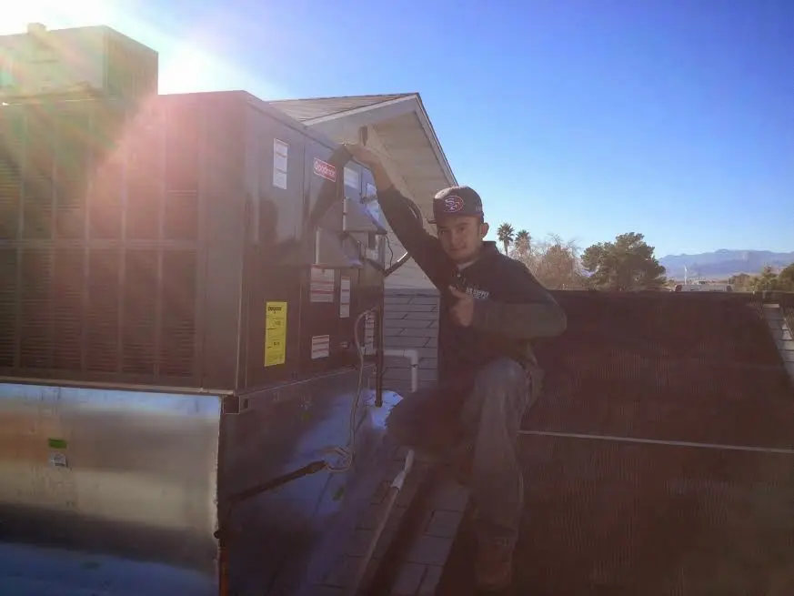 HVAC technician performing HVAC Inspection on a rooftop unit in Roxboro